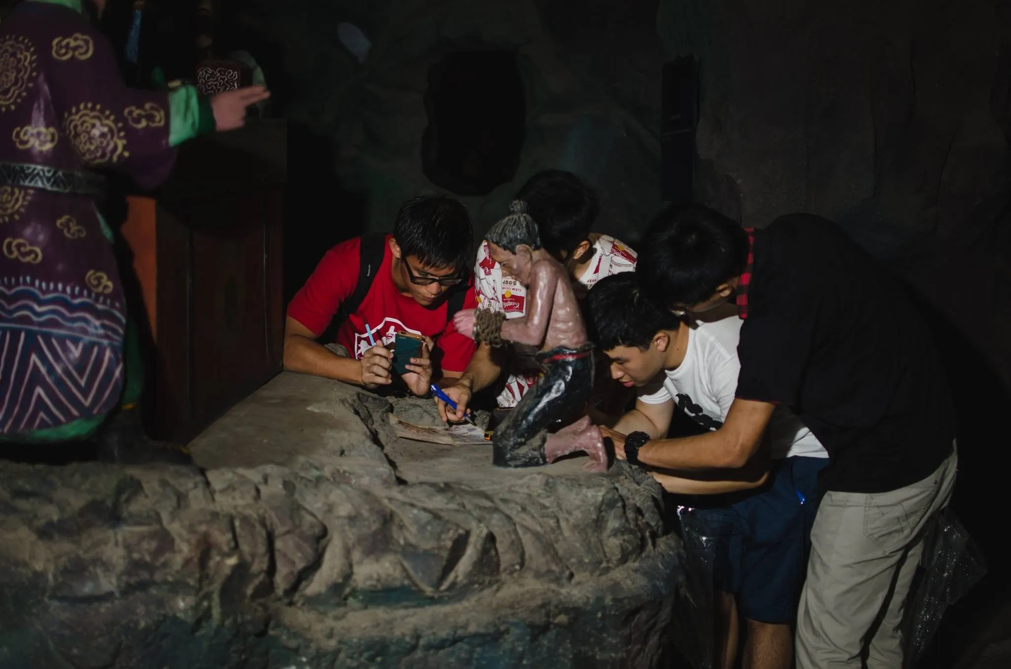 A player holding a phone up to a clue during Journey to the End and Back at Haw Par Villa